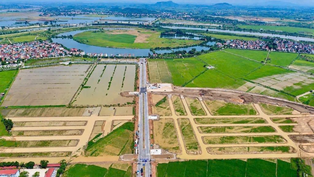 Ảnh chụp từ trên cao hiện trạng công trường Vinhomes King Park tại phường Kinh Bắc, thấy rõ nền đường đã đắp giữa ruộng và khúc uốn sông Cầu