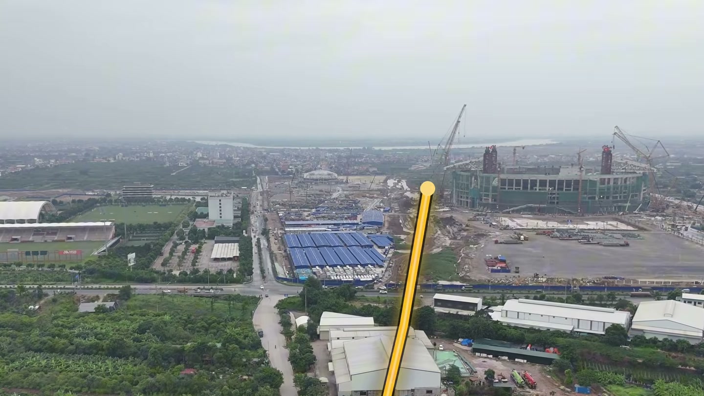 Ảnh flycam hướng tuyến đại lộ Đông Tây vẽ bằng đường màu vàng, chạy về phía công trường sân bóng đá PVF
