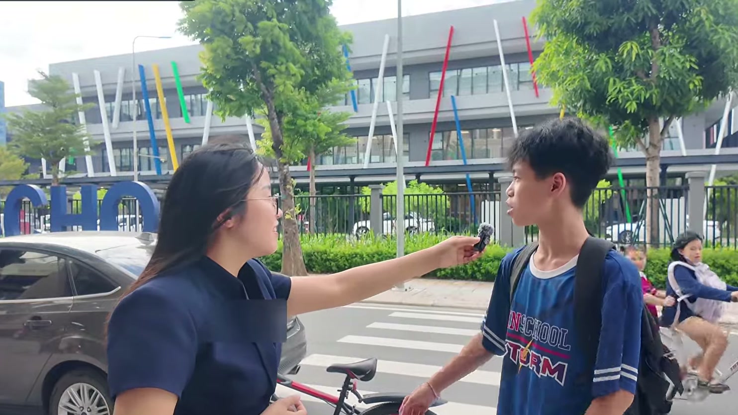 Phương Hoa phỏng vấn hai học sinh trước cổng trường Vinschool Ocean Park 2